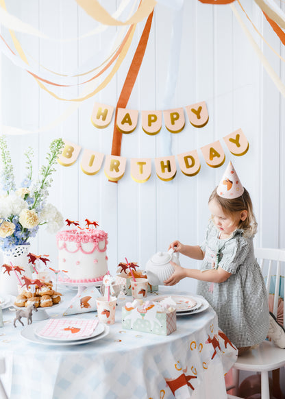 Child wearing a horse party hat at a pastel pony-themed birthday table, available at Confetti My Party Toronto.