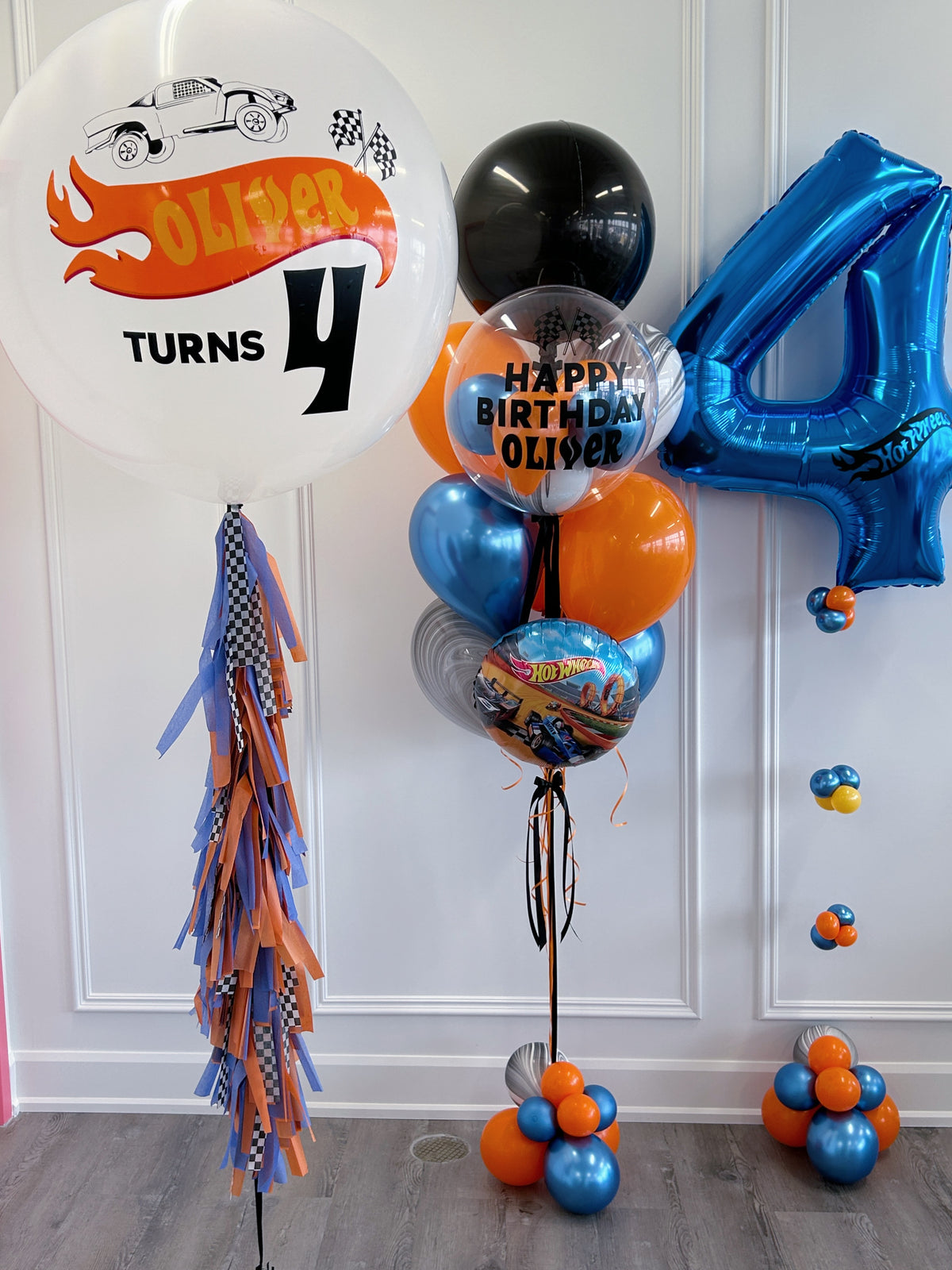 Hot Wheels-inspired birthday balloon package in blue, orange, black + silver with personalized racing balloons.
