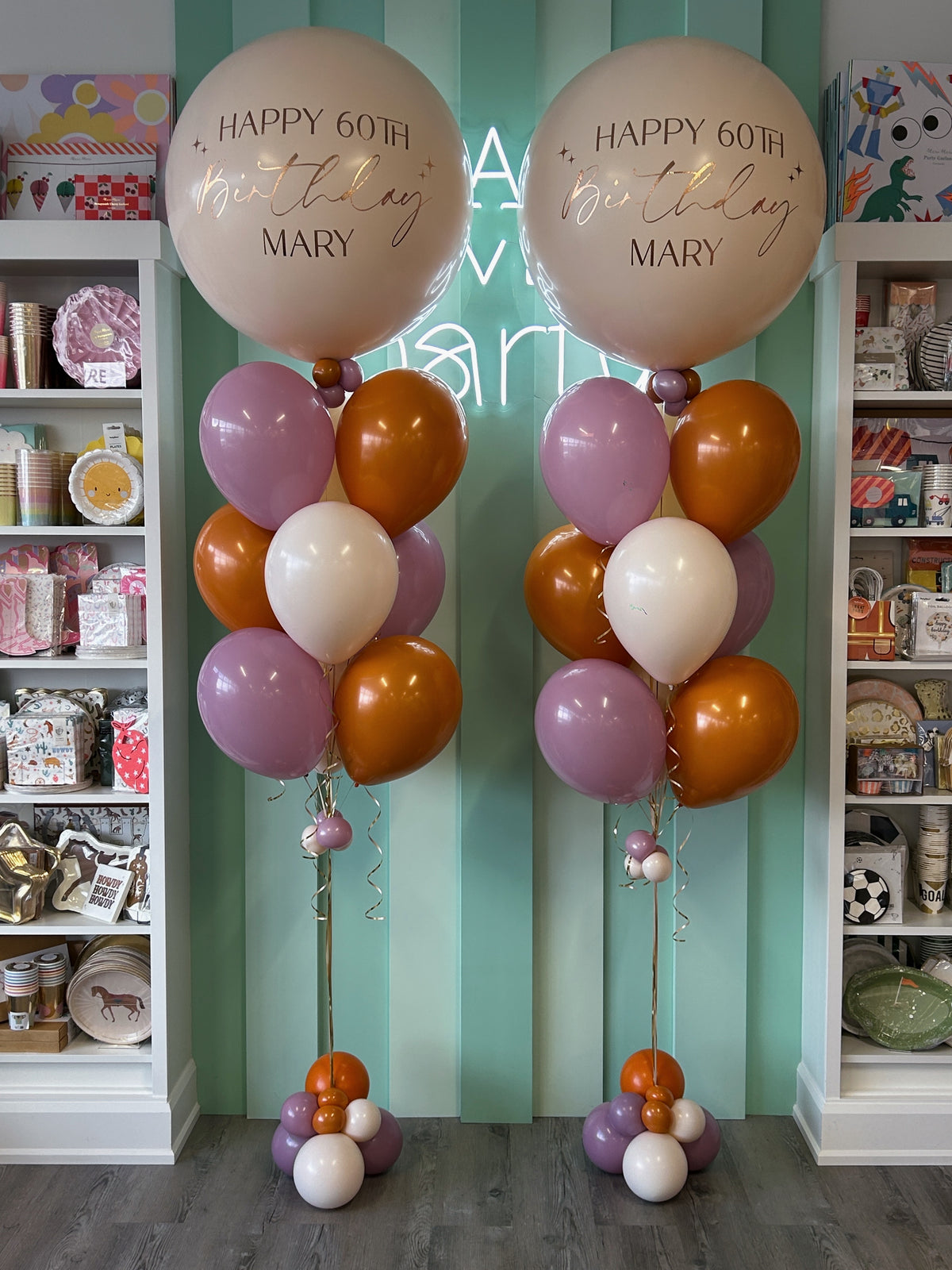 Two personalized jumbo birthday balloon bundles featuring cream balloons with gold lettering, mauve, burnt orange and ivory helium bouquets and decorative balloon bases in Toronto.