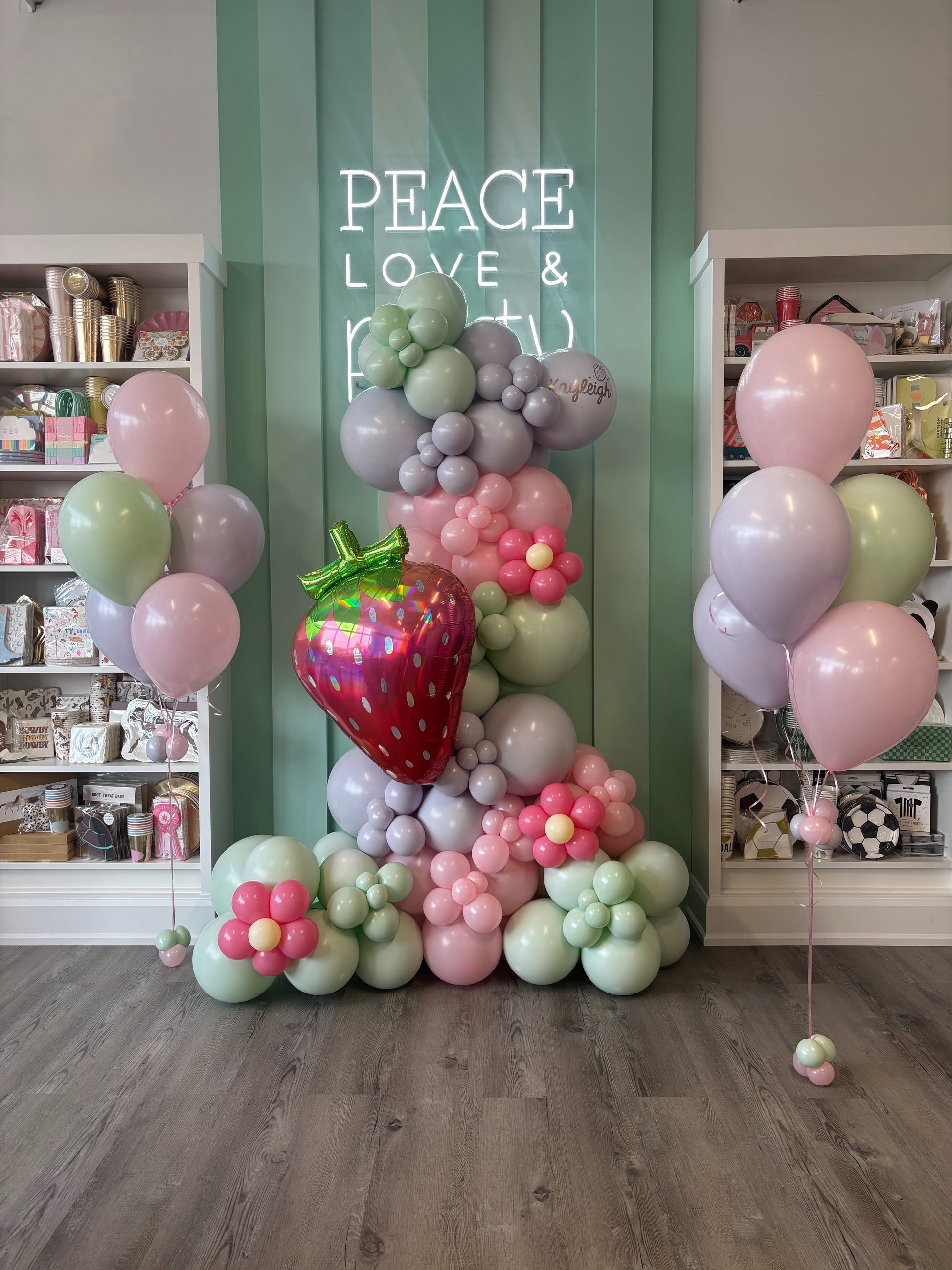 Close-up of jumbo strawberry foil balloon with pastel balloon garland and floral details for a Toronto summer birthday party.