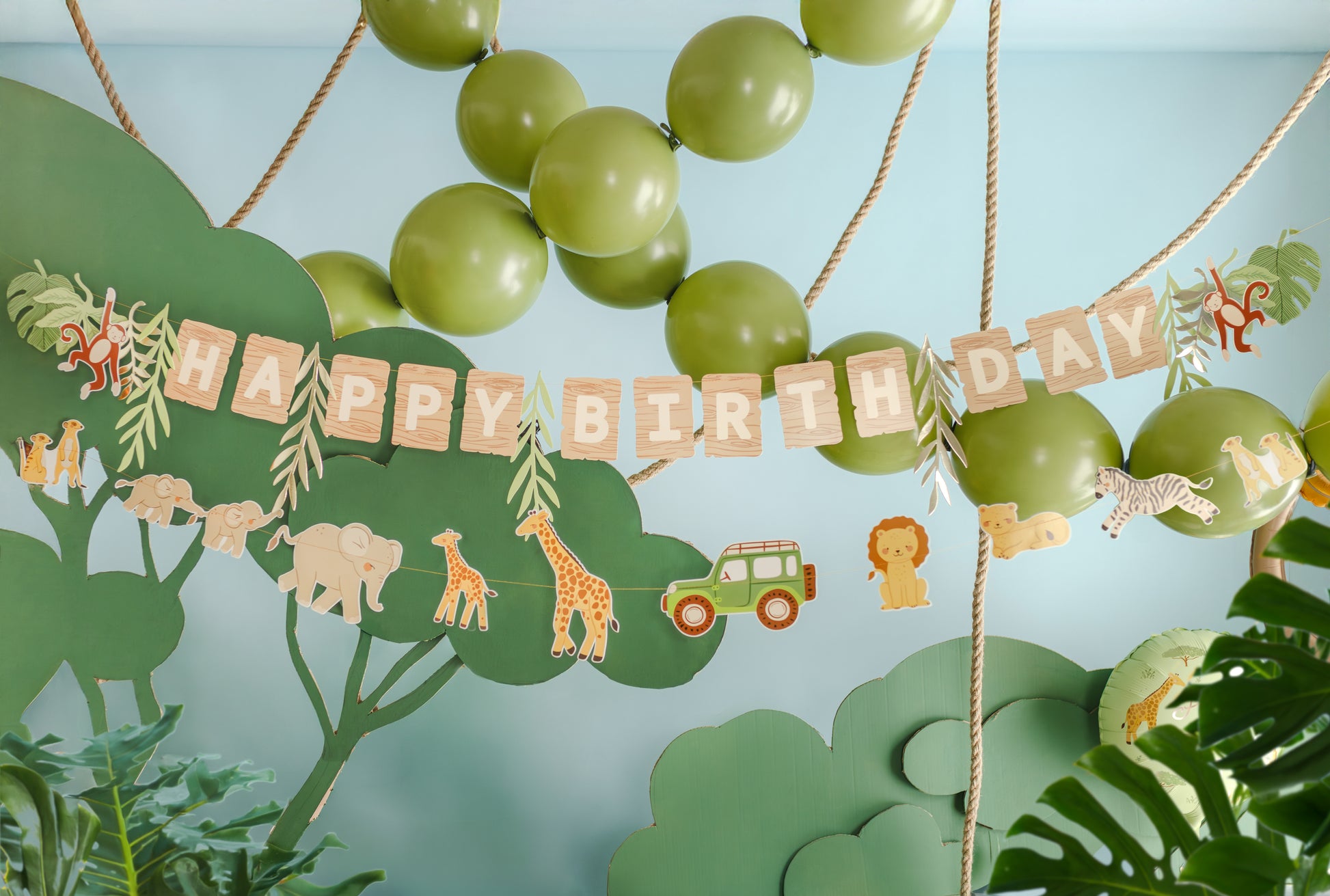 Safari themed happy birthday banner styled with jungle party decor available at our Toronto party shop