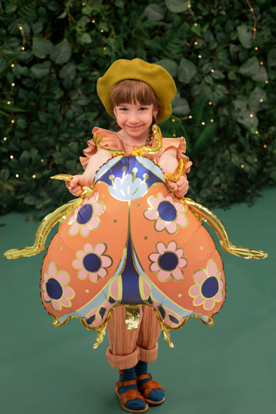 child holding ladybug foil balloon