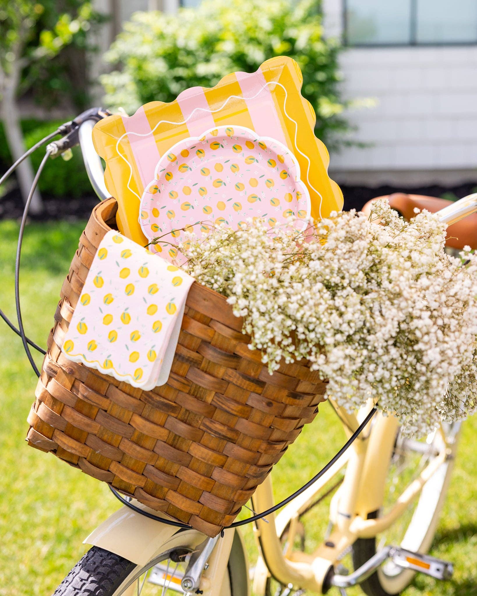 Lemon-themed plates and napkins arranged in a picnic basket with flowers in Toronto