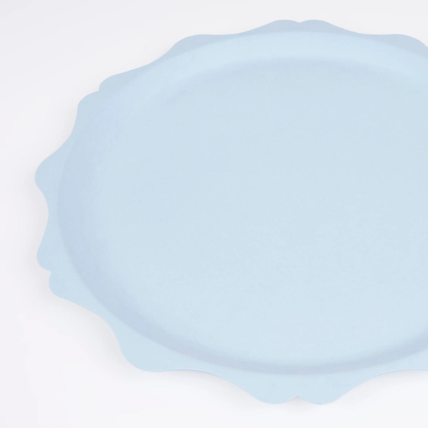 Close-up of light blue scalloped paper plate with soft wavy edges