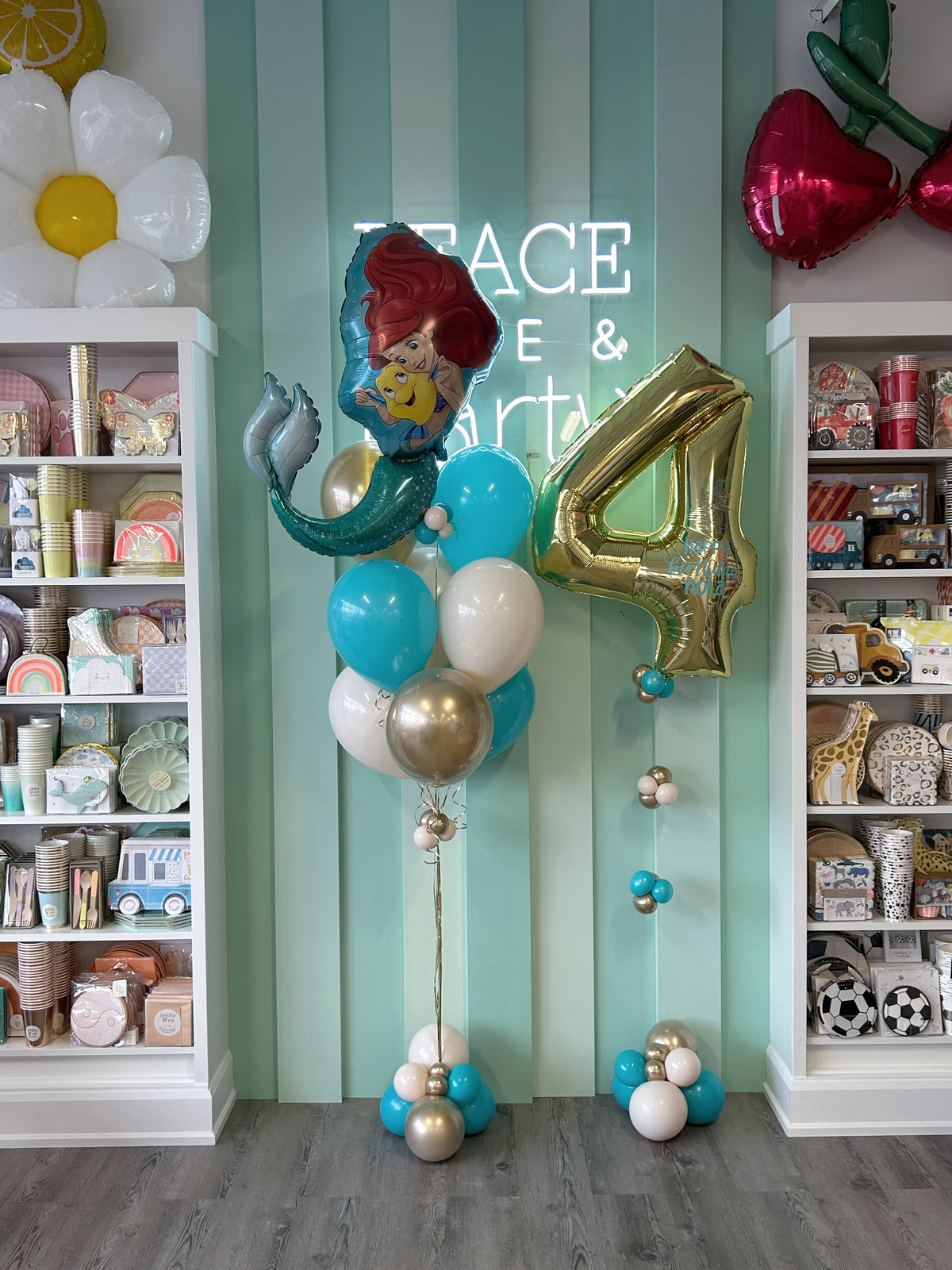 Little Mermaid Ariel birthday balloon bundle featuring an Ariel foil balloon, personalized gold number 4, turquoise, white and champagne gold helium balloons with decorative bases in Toronto.