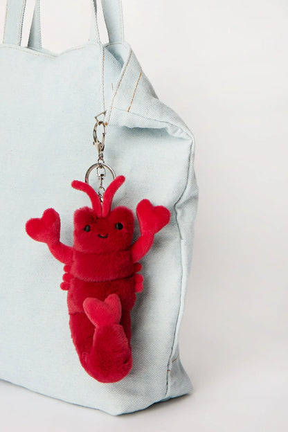 Red plush lobster keychain charm clipped onto tote bag available in Toronto and shipping across Canada