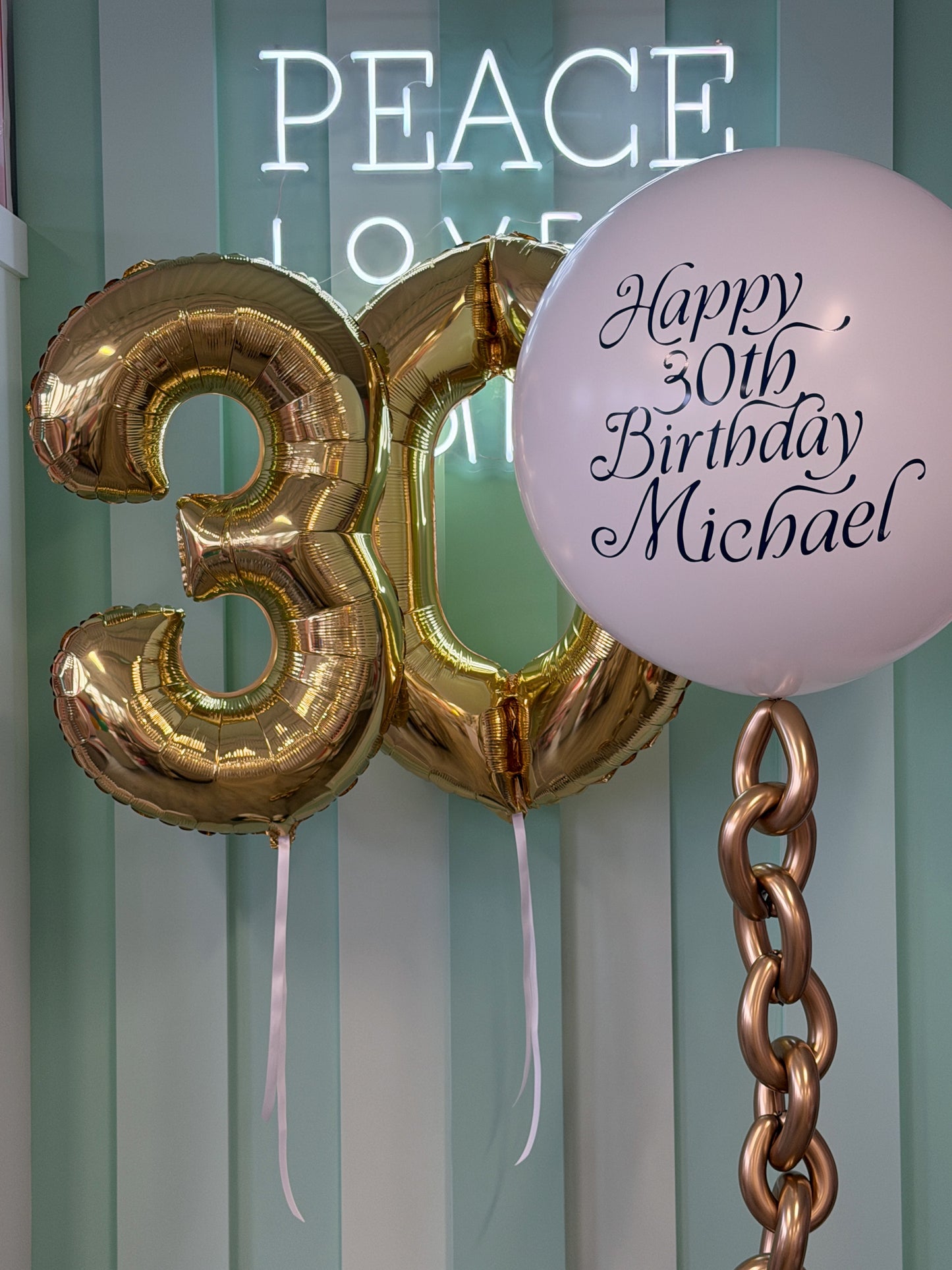 Nautical birthday balloon bundle with gold number balloons, personalized white jumbo balloon and metallic gold balloon chain in Toronto.