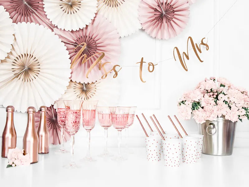 rose gold bridal shower set up with paper party fans and banner