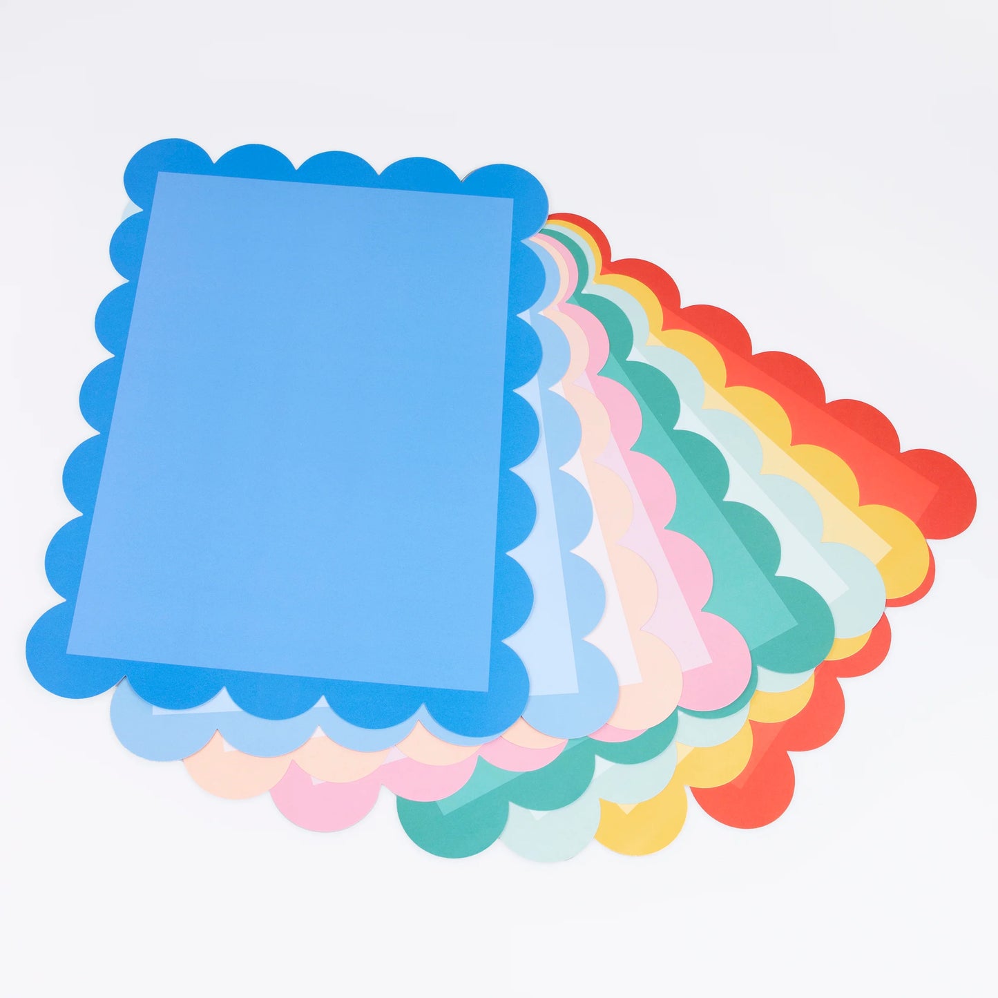 Stack of colorful scalloped-edge paper sheets with blue sheet on top