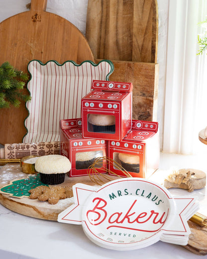Festive baking scene with Mrs. Claus Bakery plates and red cupcake boxes, ideal for holiday dessert tables across Canada.