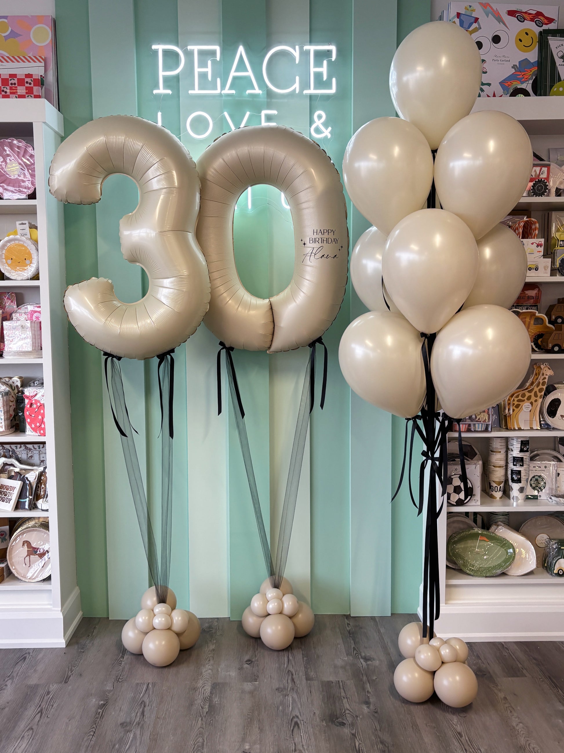 Neutral-toned milestone number balloons paired with a matching balloon bouquet, styled as a birthday set and sold in Toronto at Confetti My Party.