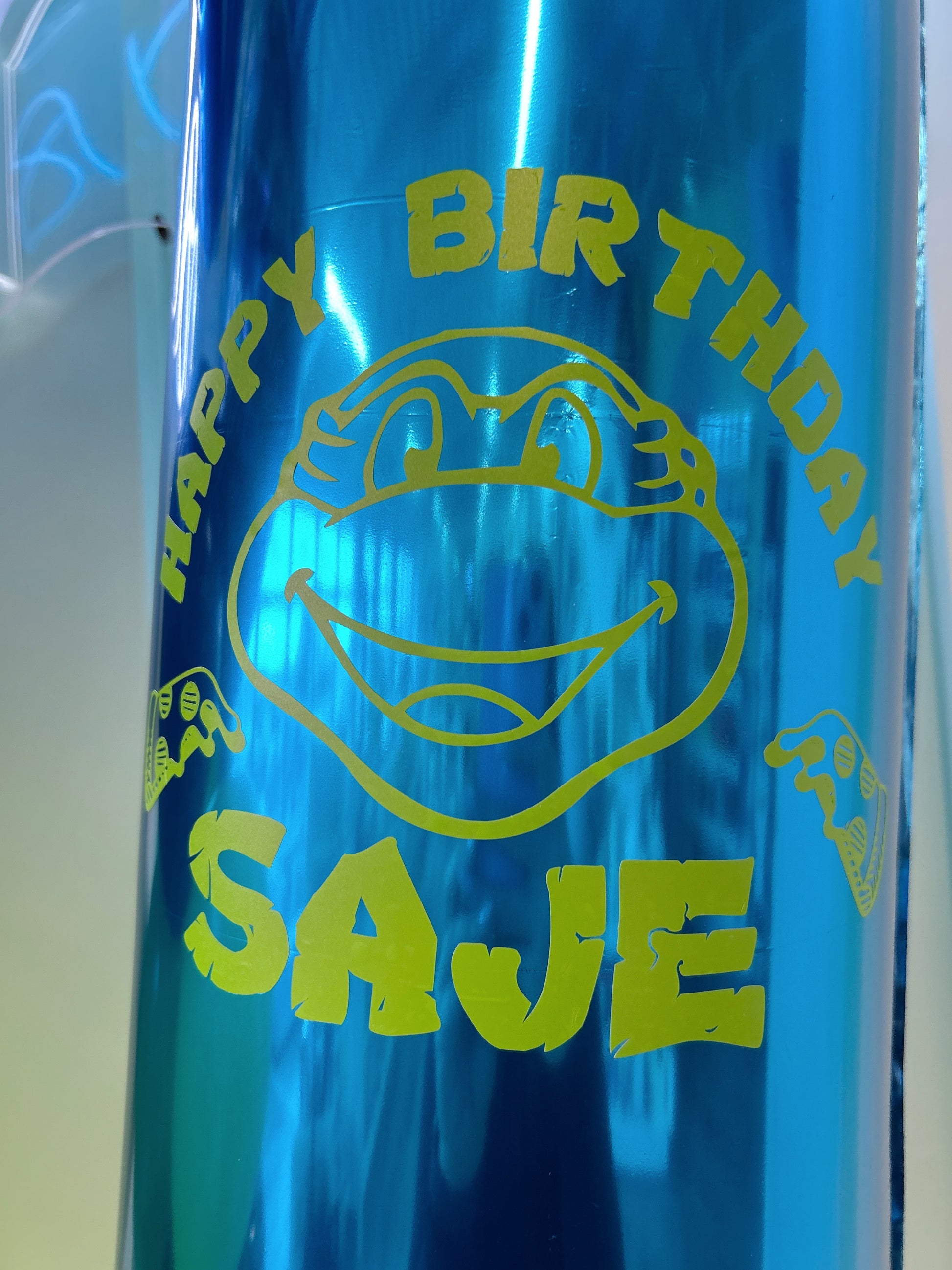 Personalized blue number 7 birthday balloon with lime green ninja turtle-inspired birthday design.