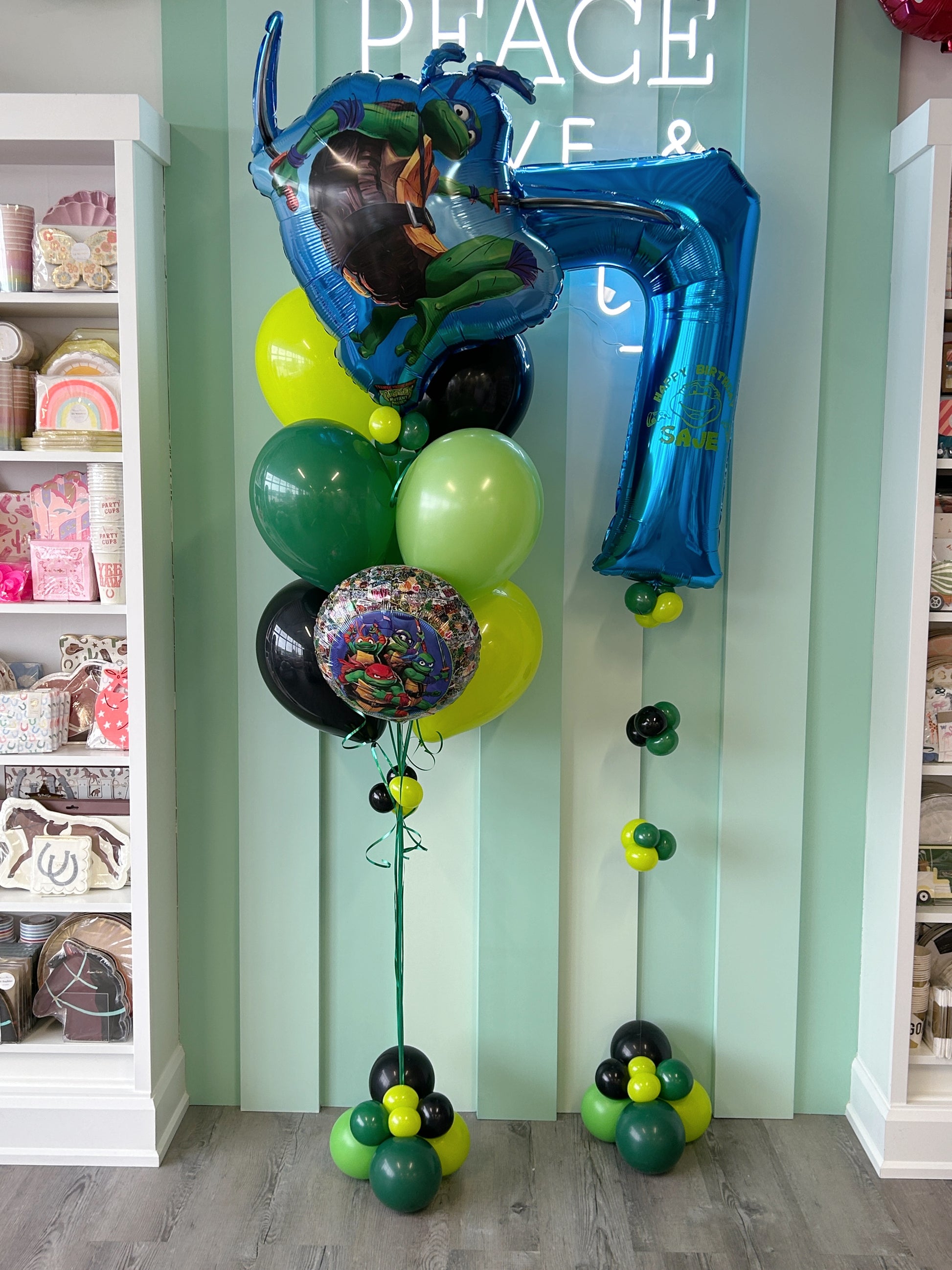 Ninja turtle birthday balloon bundle with themed foil balloons, green and black latex balloons and a personalized blue number 7 balloon.
