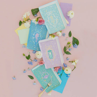 Set of colorful notebooks with floral decorations on a pink background