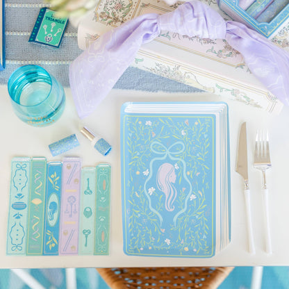 Set of decorative bookmarks and a notebook with mermaid design on a table.