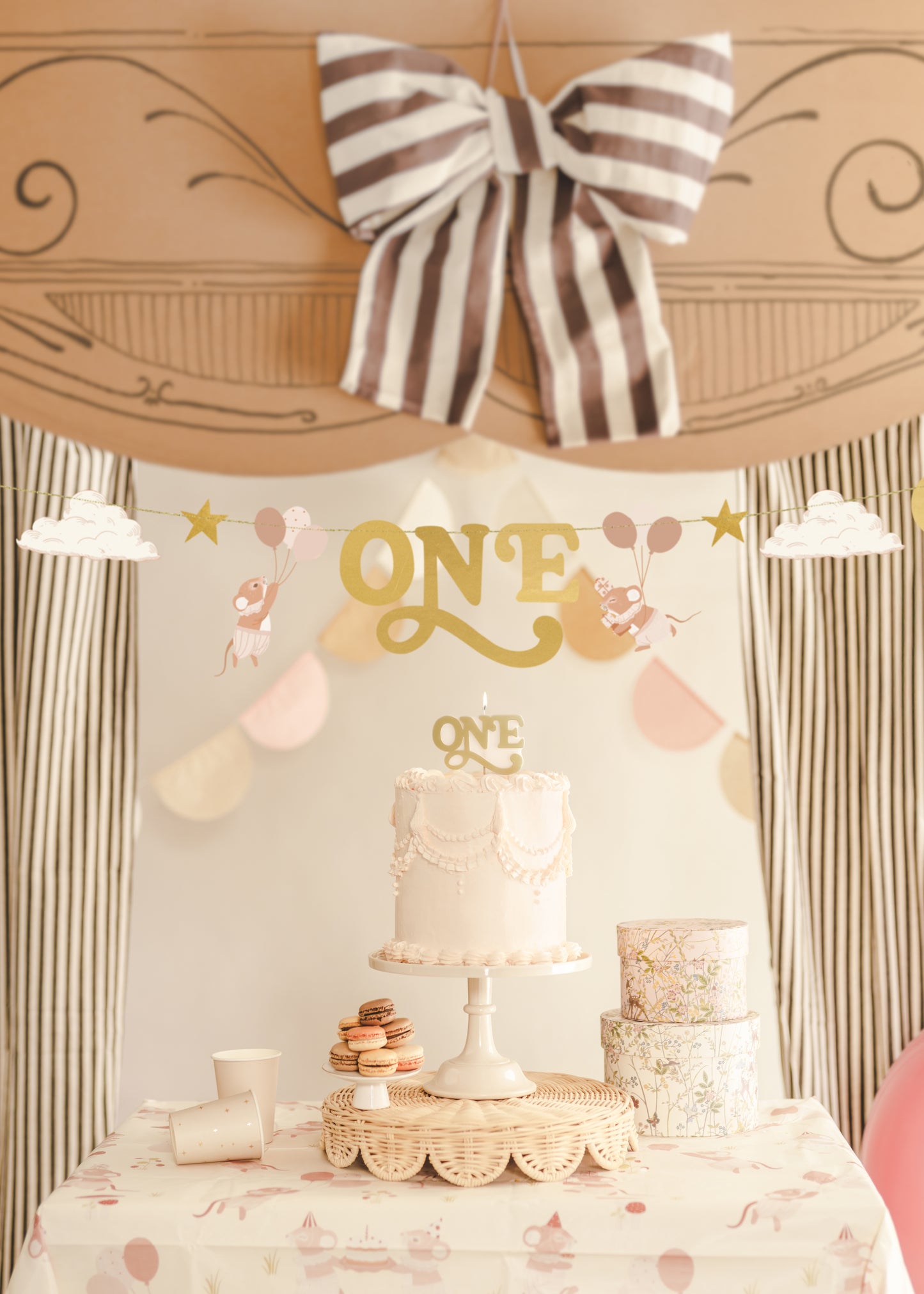 Gold “ONE” birthday candle styled on a first birthday cake display available at our Toronto party shop