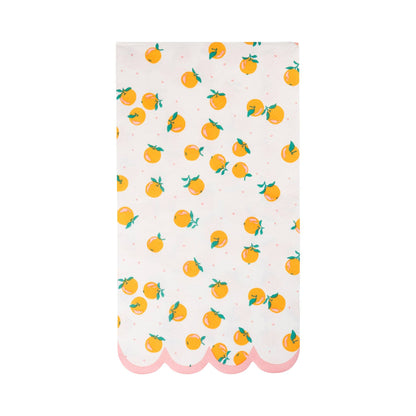 White dinner napkin with orange fruit print and pink scalloped border, perfect for Toronto summer parties.