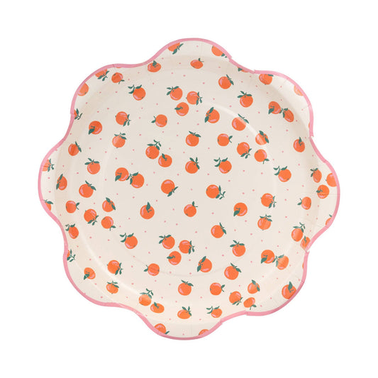 Round scalloped paper plates with scattered orange fruit print, perfect for summer parties in Toronto.
