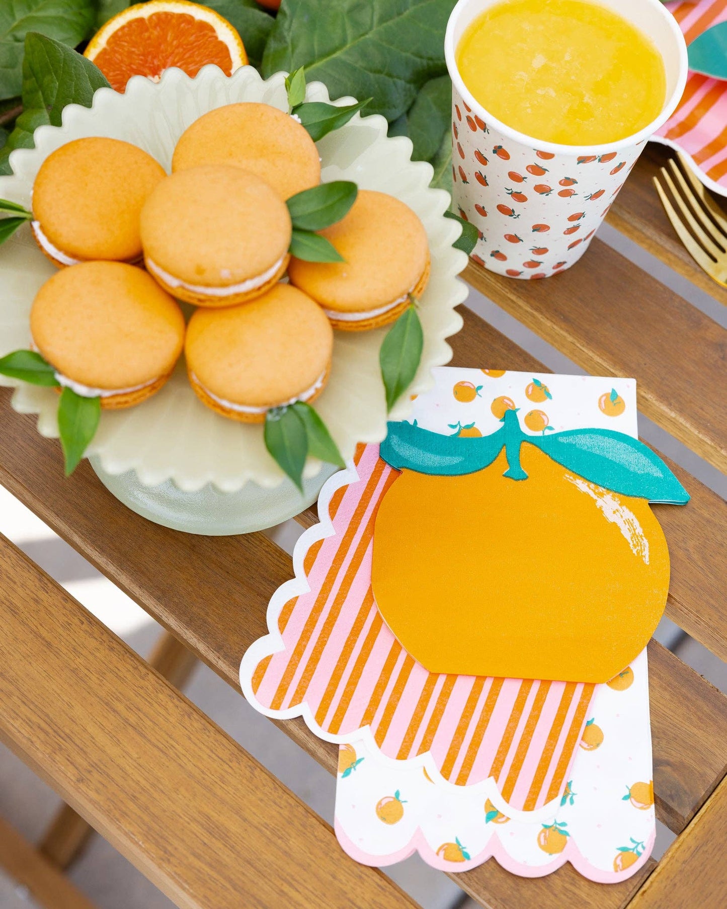 Citrus-inspired table setting with orange napkins, striped plates, and fresh fruit décor in Toronto.