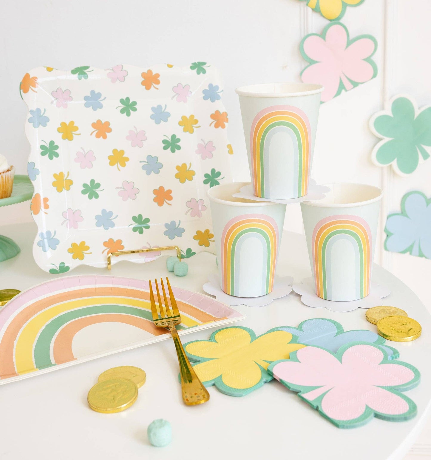 Pastel rainbow shaped plates styled on a party table with matching rainbow cups and spring décor