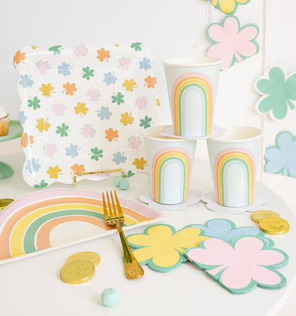 Pastel rainbow shaped plates styled on a party table with matching rainbow cups and spring décor