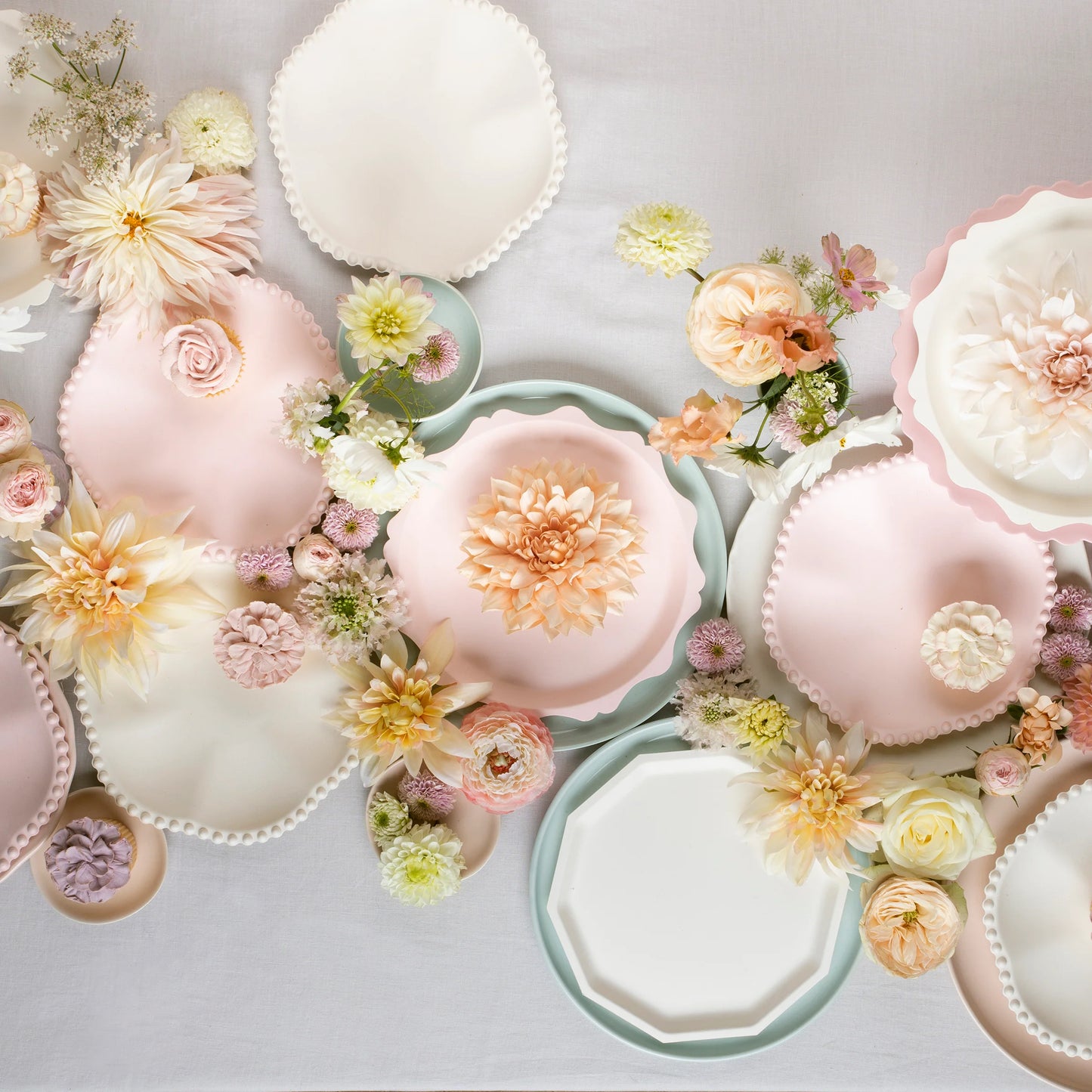 Elegant pastel scalloped plates styled with fresh florals for a soft tablescape
