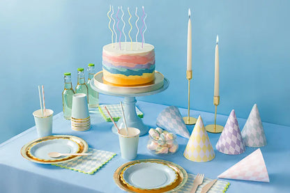 pastel birthday candles on cake with table set up