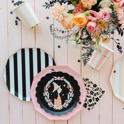 Decorative plates with artistic designs on a wooden surface with flowers and candles.
