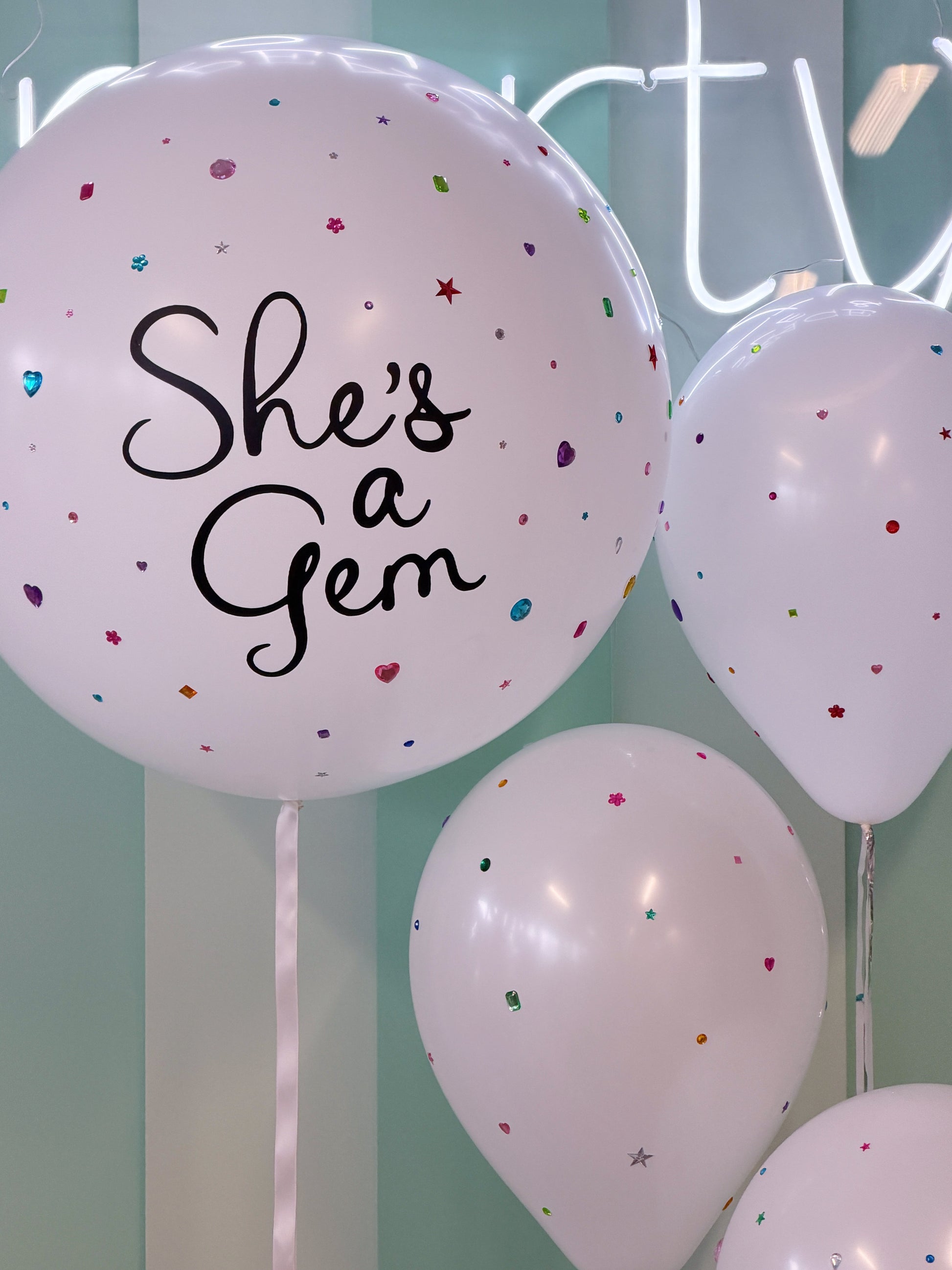Personalized “She’s a Gem” jumbo balloon with colourful rhinestone and gem details, paired with coordinating bedazzled balloons in Toronto.