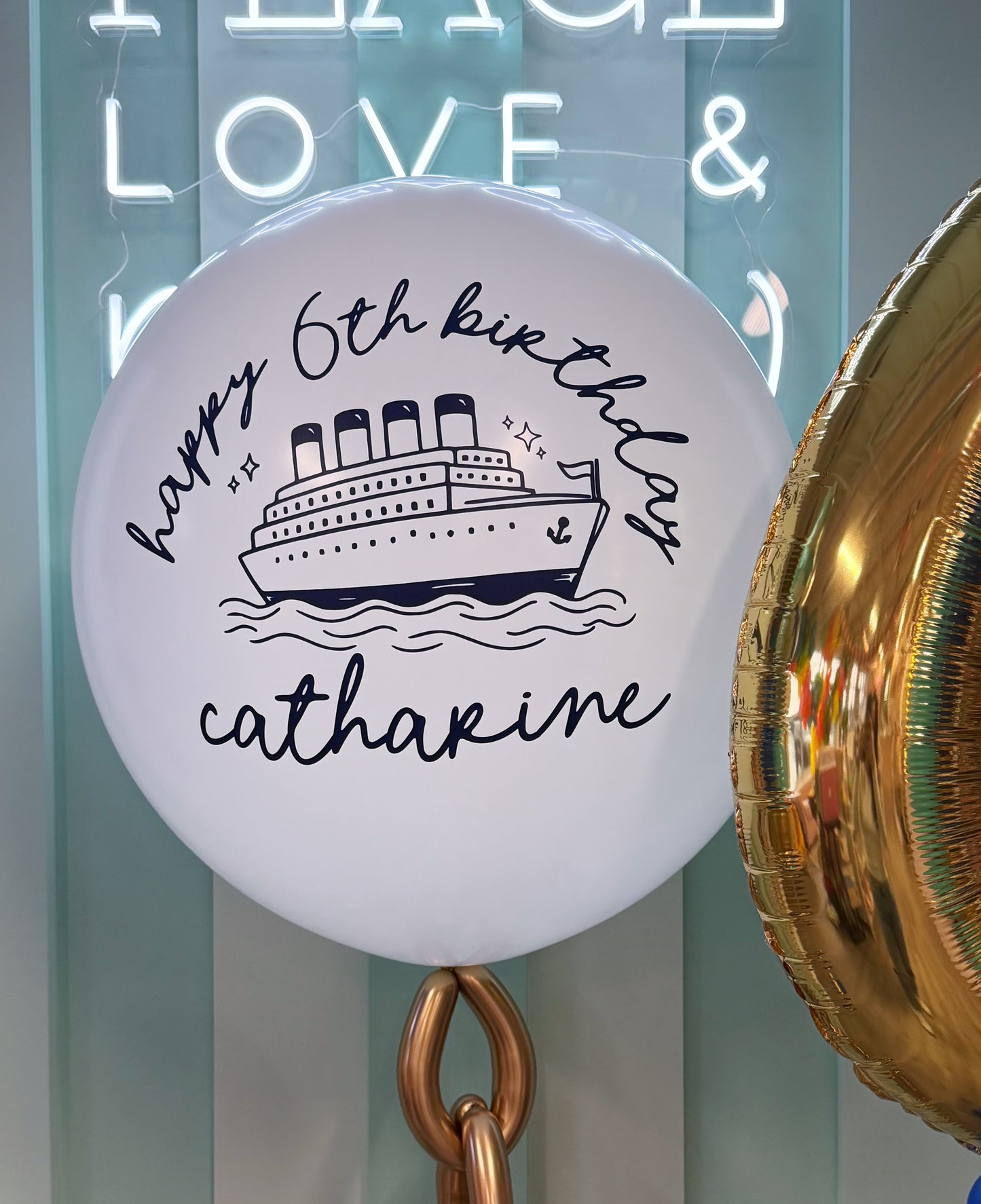 Ocean-themed birthday balloon bundle with anchor, dolphin, personalized birthday balloon and blue and gold balloons in Toronto.