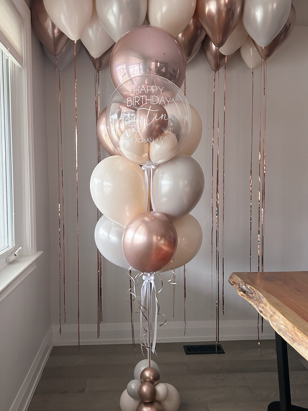 Personalized clear birthday bubble balloon with rose gold, cream and pearl white balloons in Toronto.