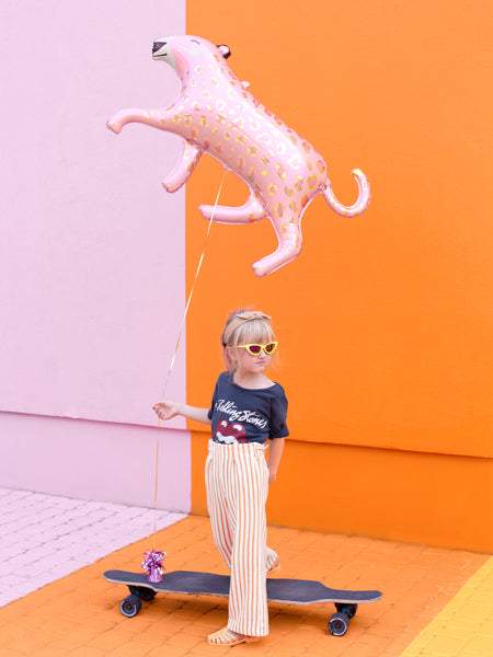 child holding pink leopard foil balloon