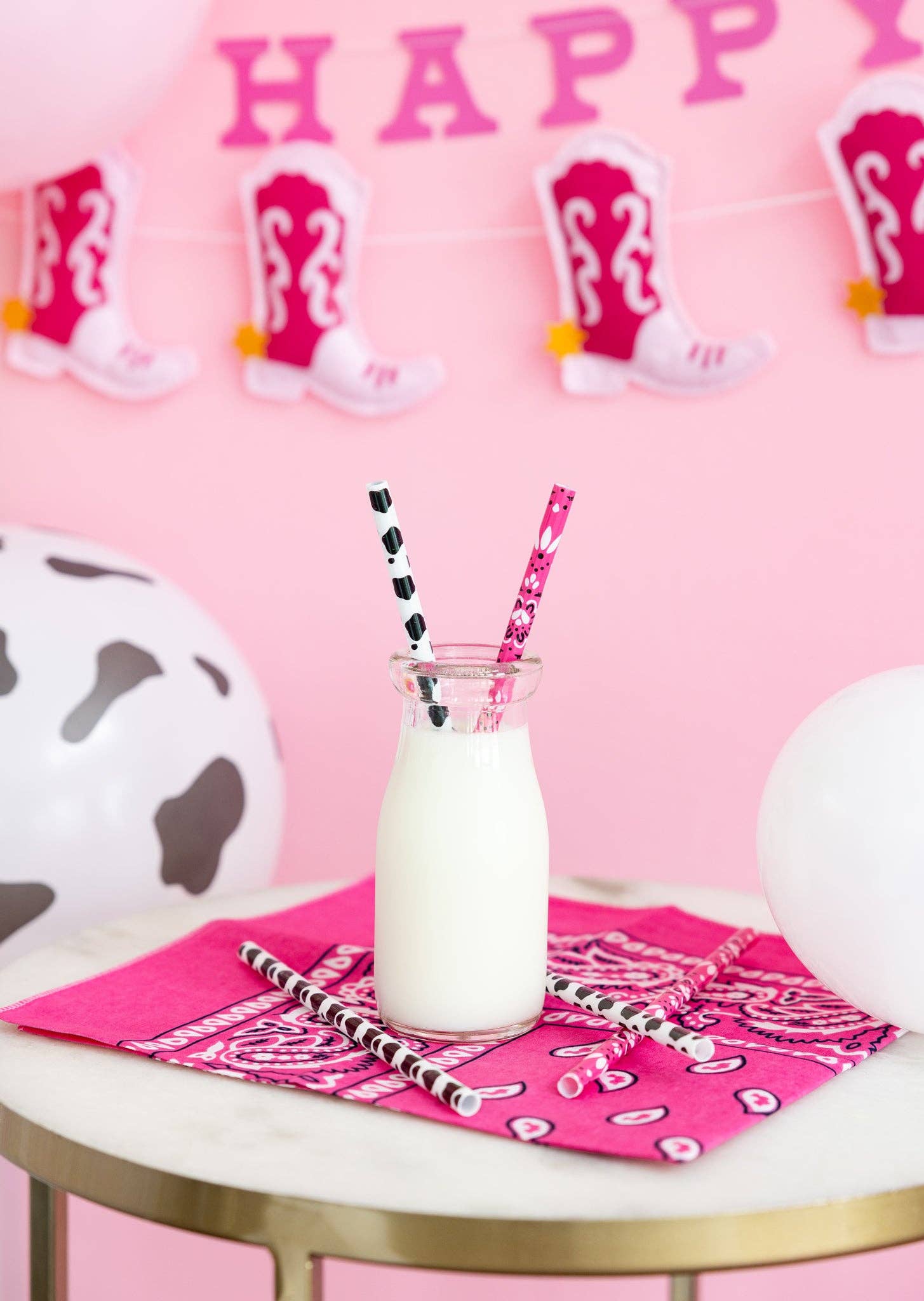Pink cowgirl straws styled with milk bottle and western décor, Toronto party setup.