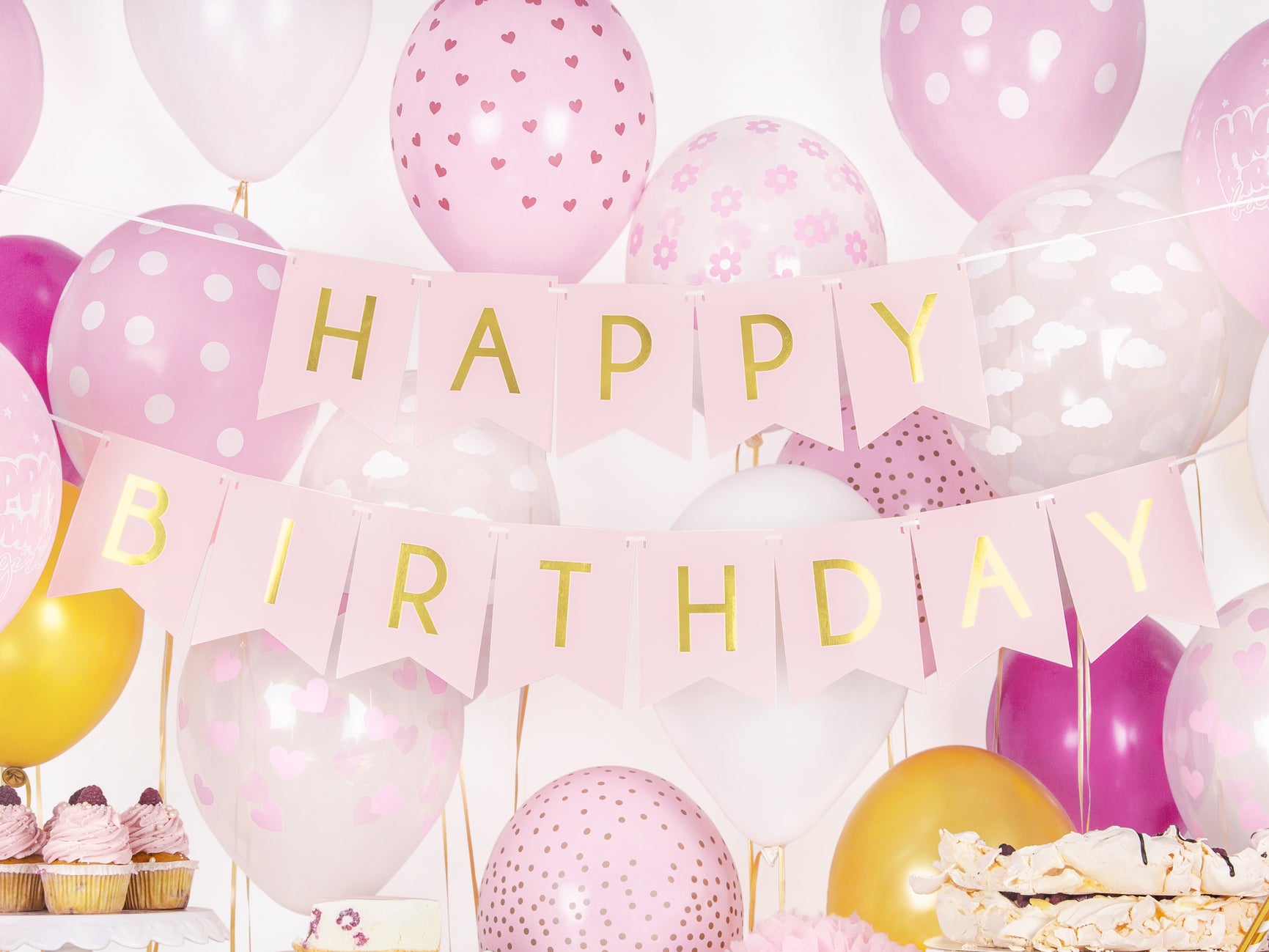 Pink and gold Happy Birthday banner styled with balloons at a party setup, Toronto party supplies shipping across Canada.