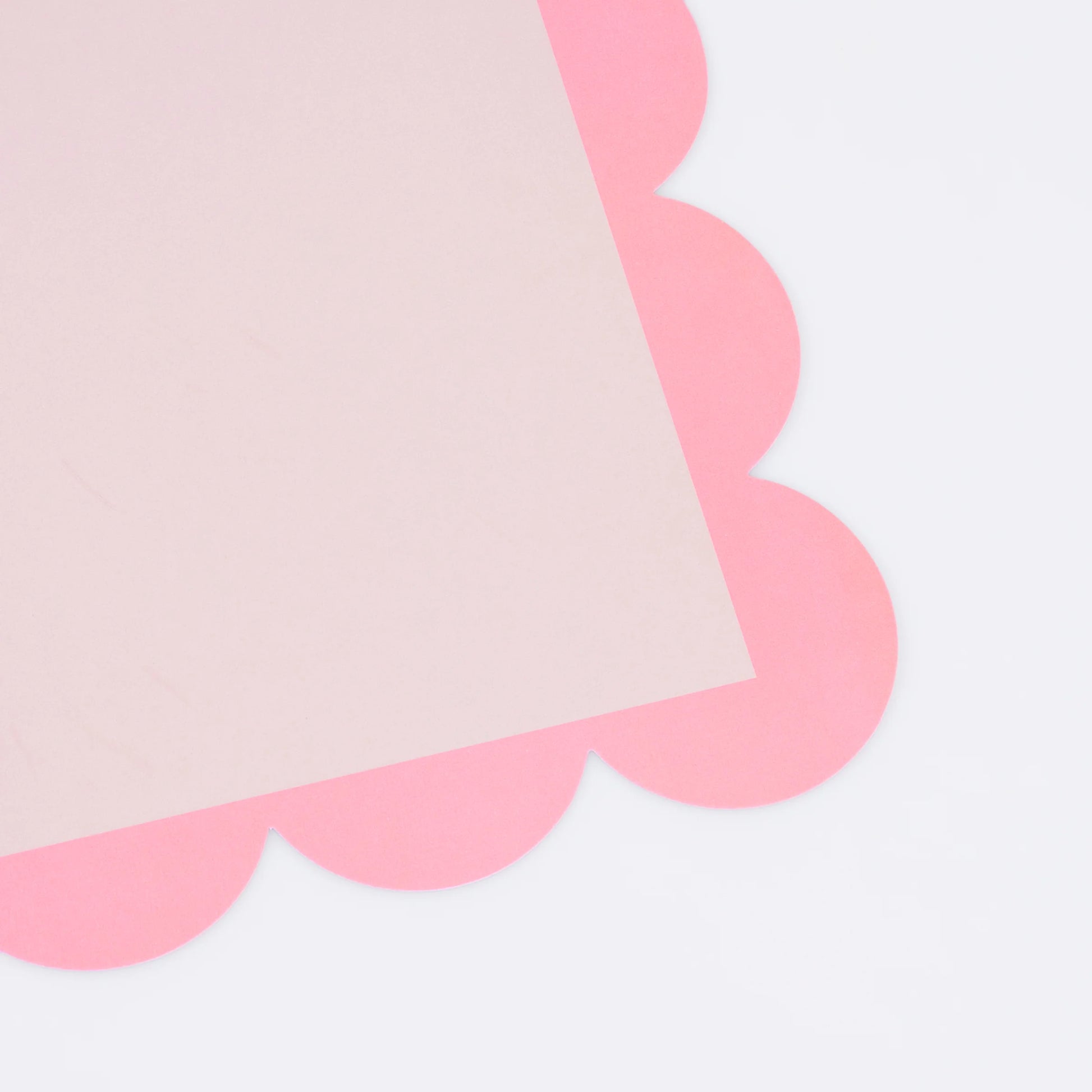 Close-up of pink scalloped-edge paper sheet corner detail