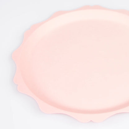 Close-up of blush pink scalloped paper plate with soft curved edges