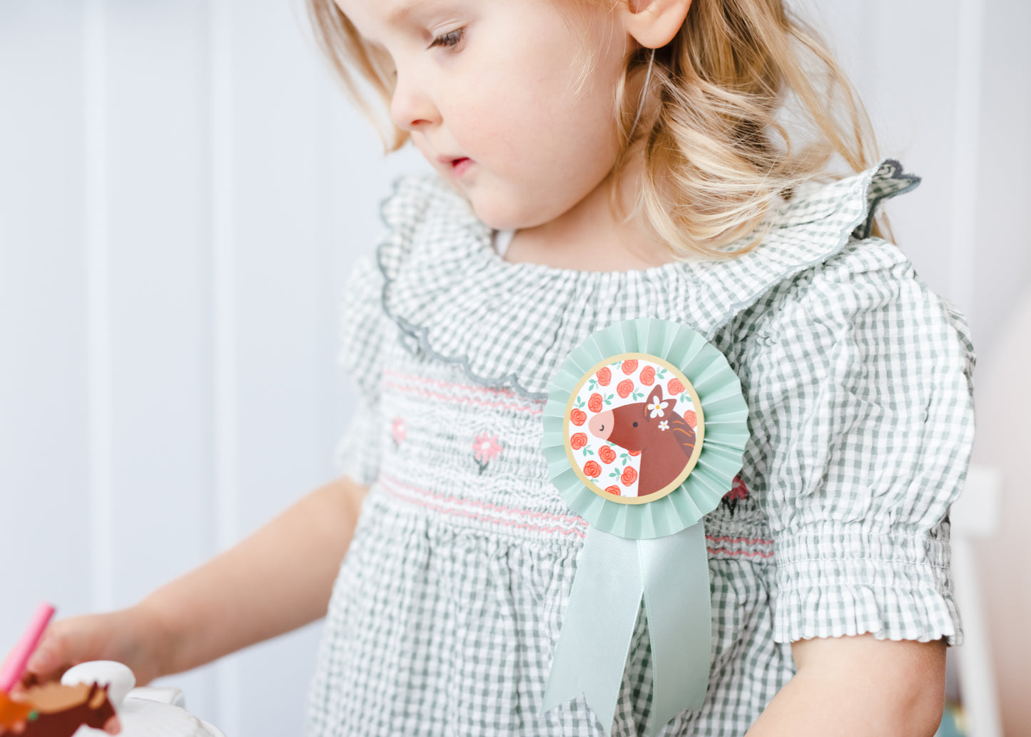 Child wearing pastel pony rosette badge with ribbon, sold at Confetti My Party Toronto