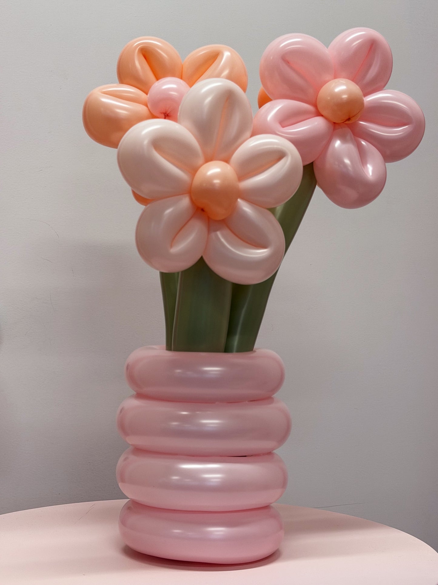 Pink and peach potted balloon flowers with hand-twisted blooms, green stems and a pink balloon pot in Toronto.