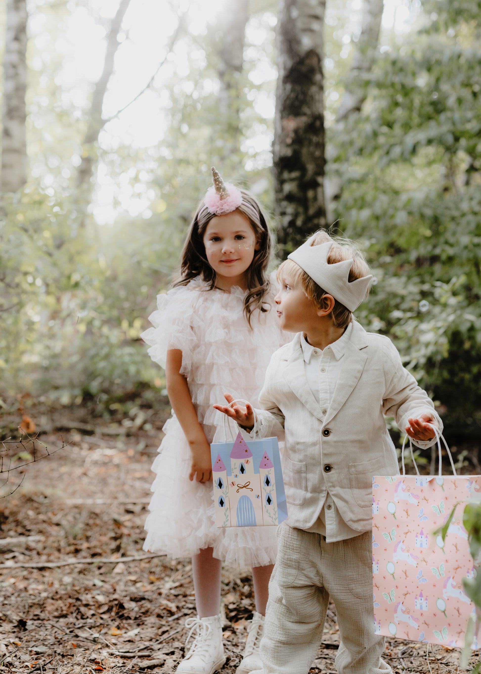 kids holding unicorn and castle gift bags 