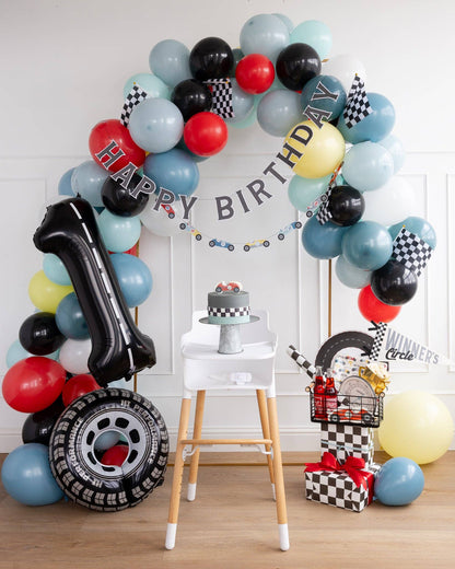 Race car first birthday decor with balloons and Winner’s Circle pennant