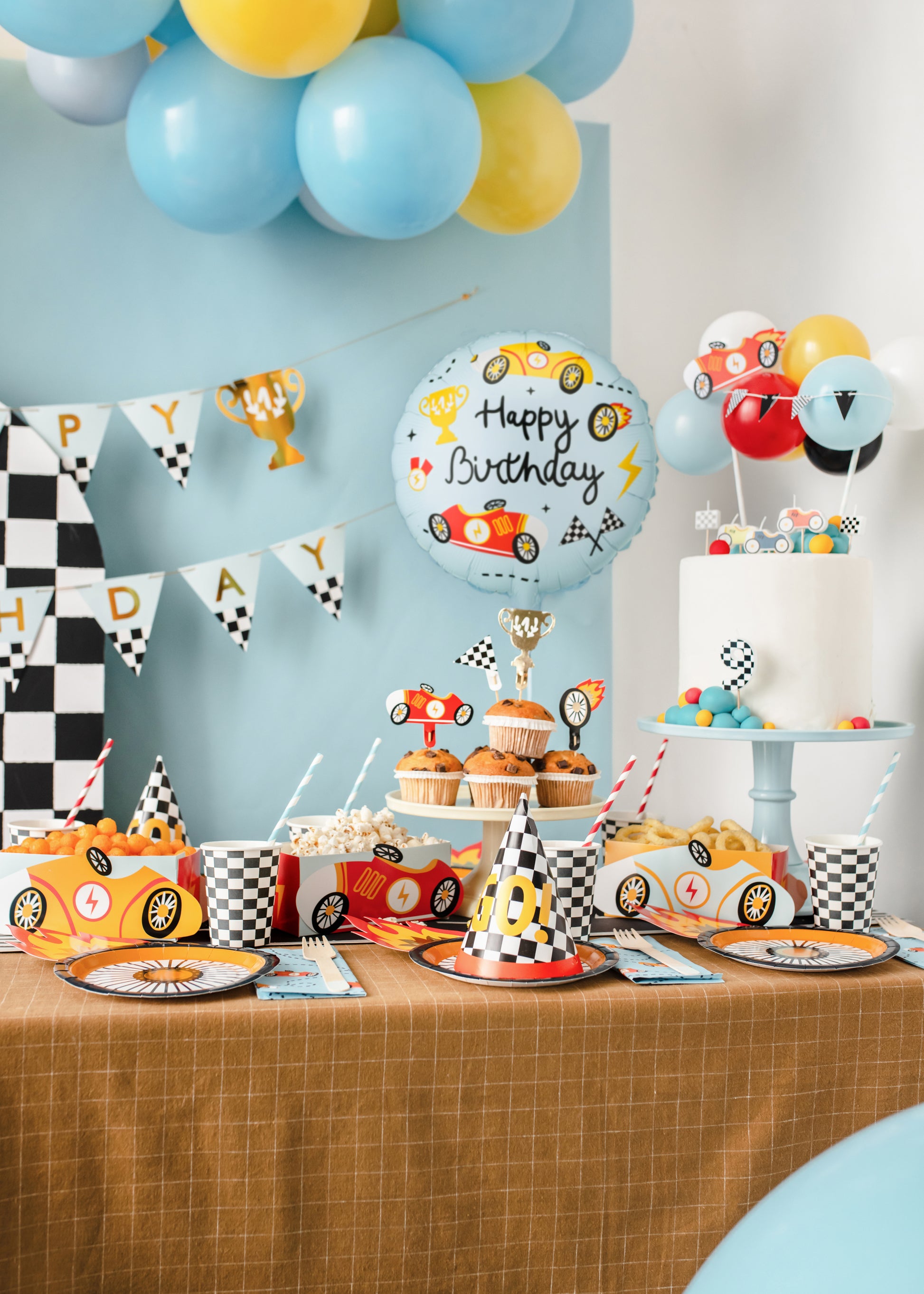 Race car Happy Birthday foil balloon styled beside matching racing party tableware available at our Toronto party shop