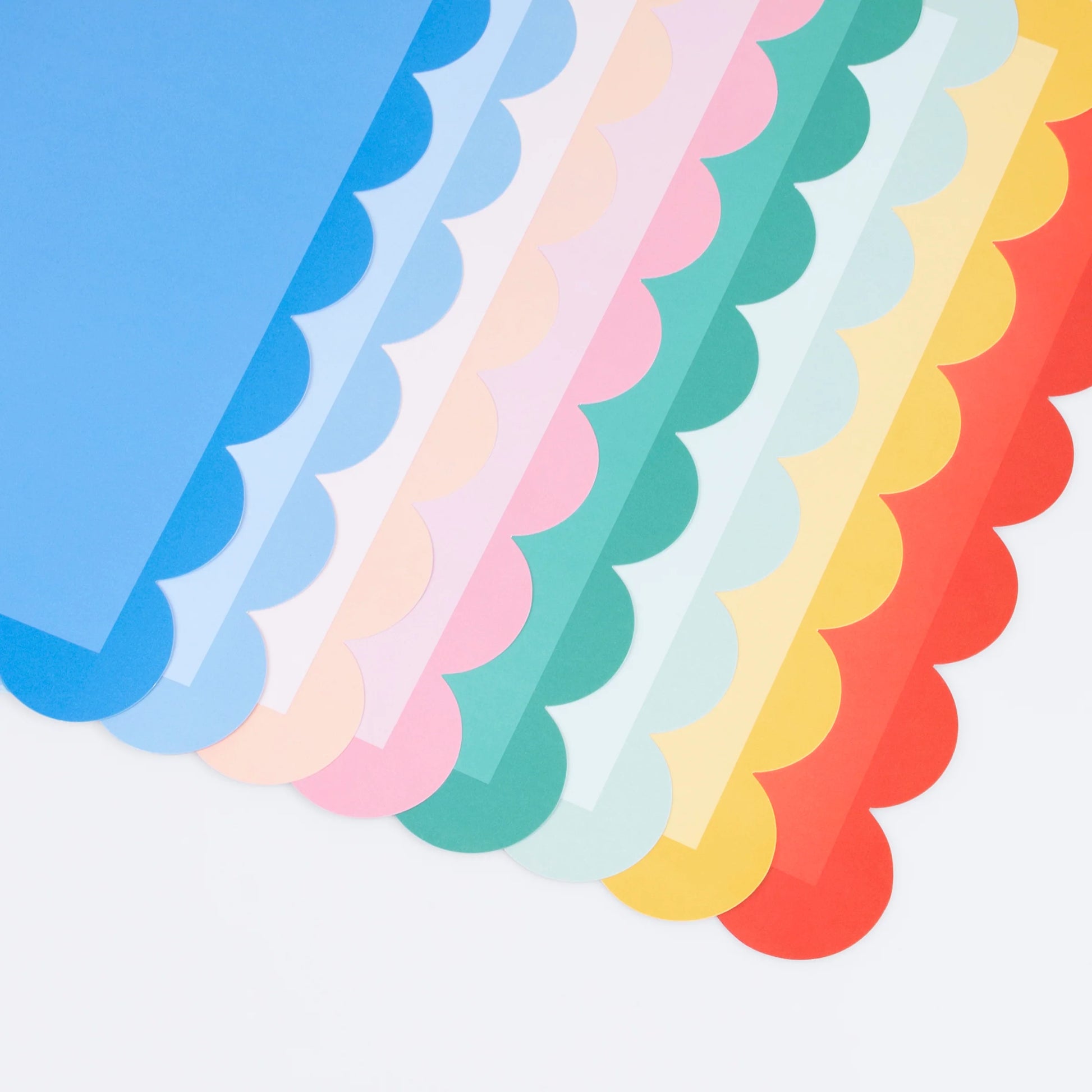 Rainbow assortment of scalloped-edge paper placemats in pastel and bold colours