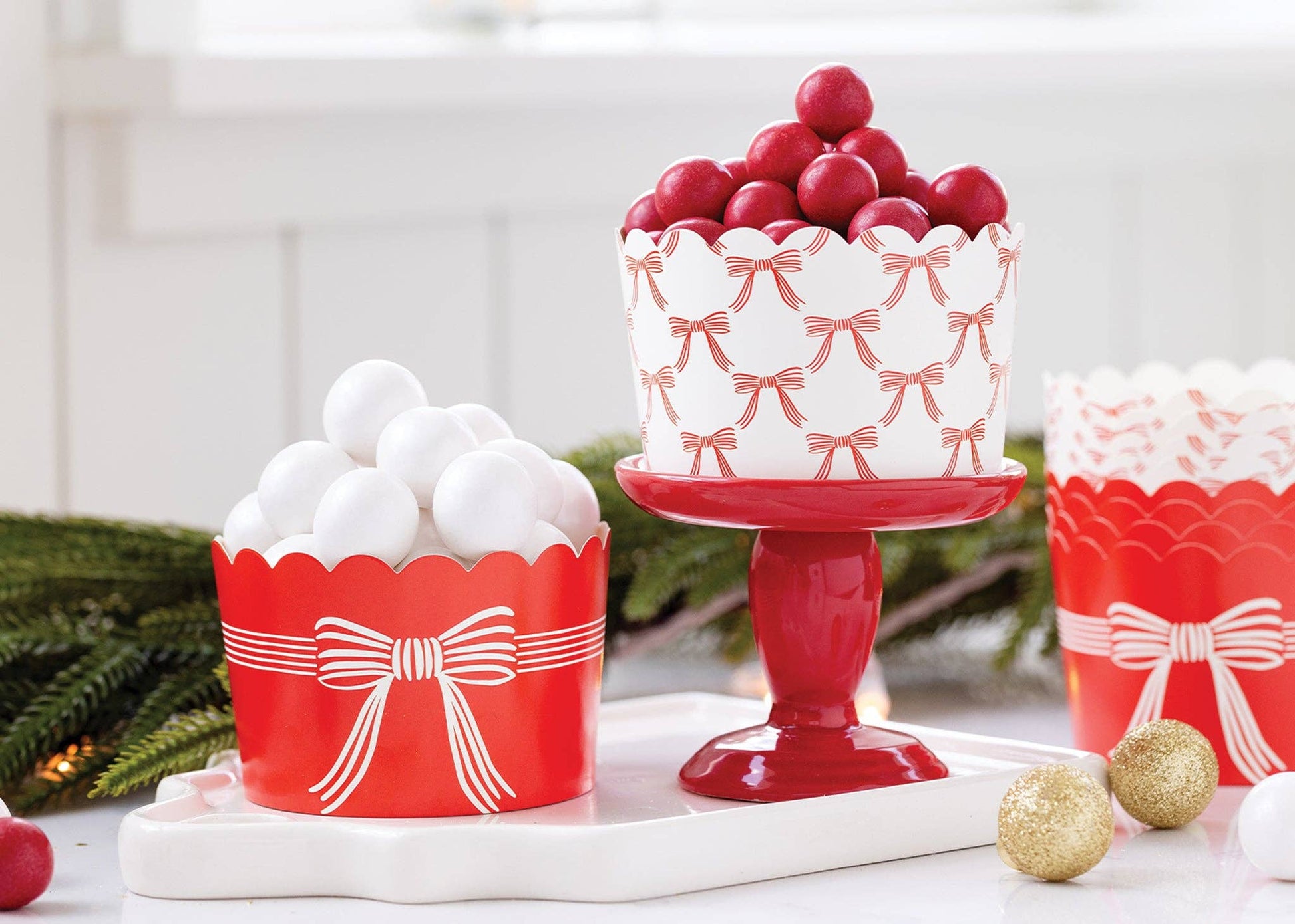 Red and white paper treat cups with festive bow print, perfect for holiday parties. Sold in Toronto at Confetti my Party.