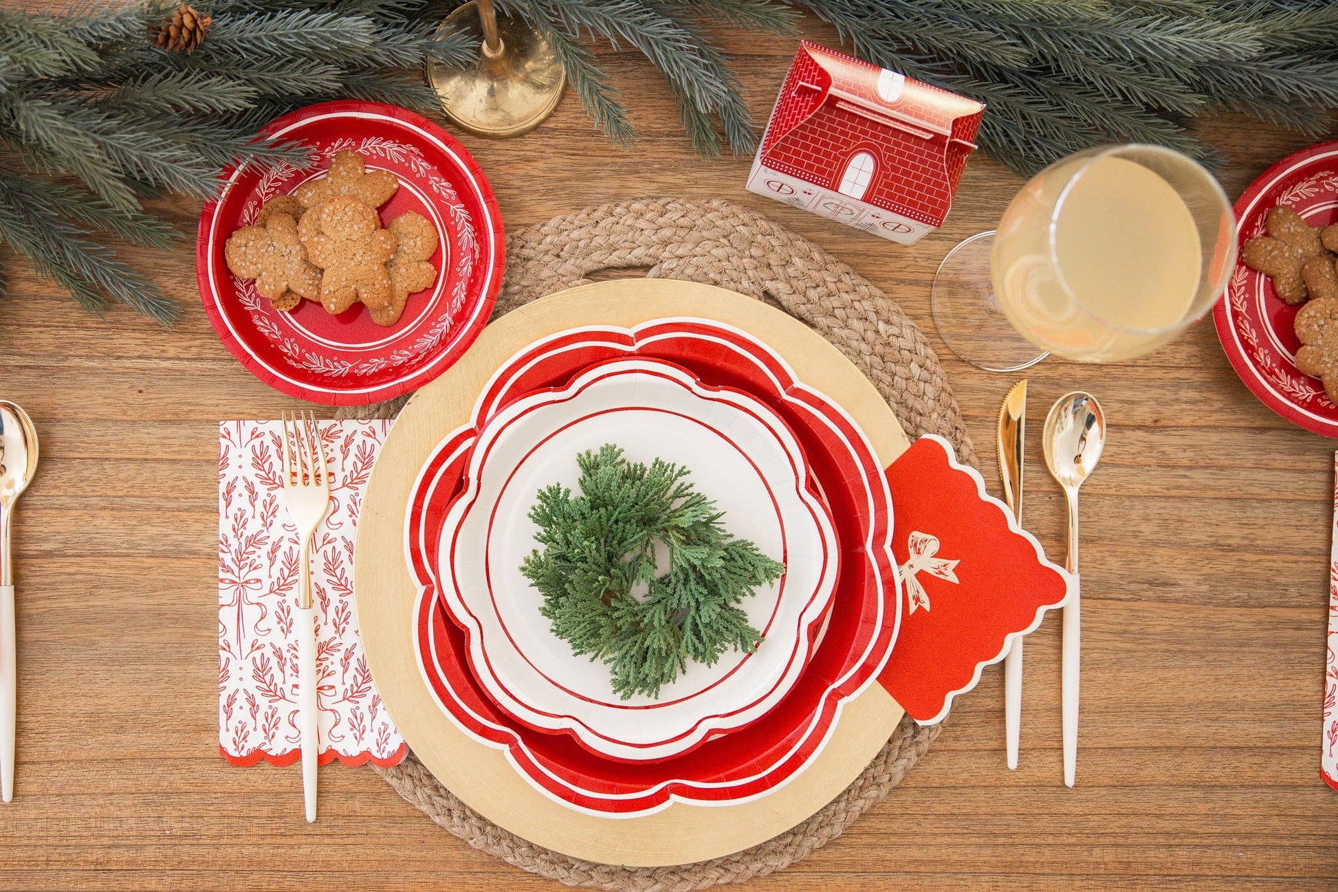 Toronto holiday tablescape with red bough napkins, scalloped plates, and Christmas greenery for a festive dining setup.
