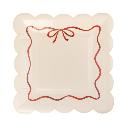 Decorative plate with scalloped edge and red bow ribbon design on a white background.