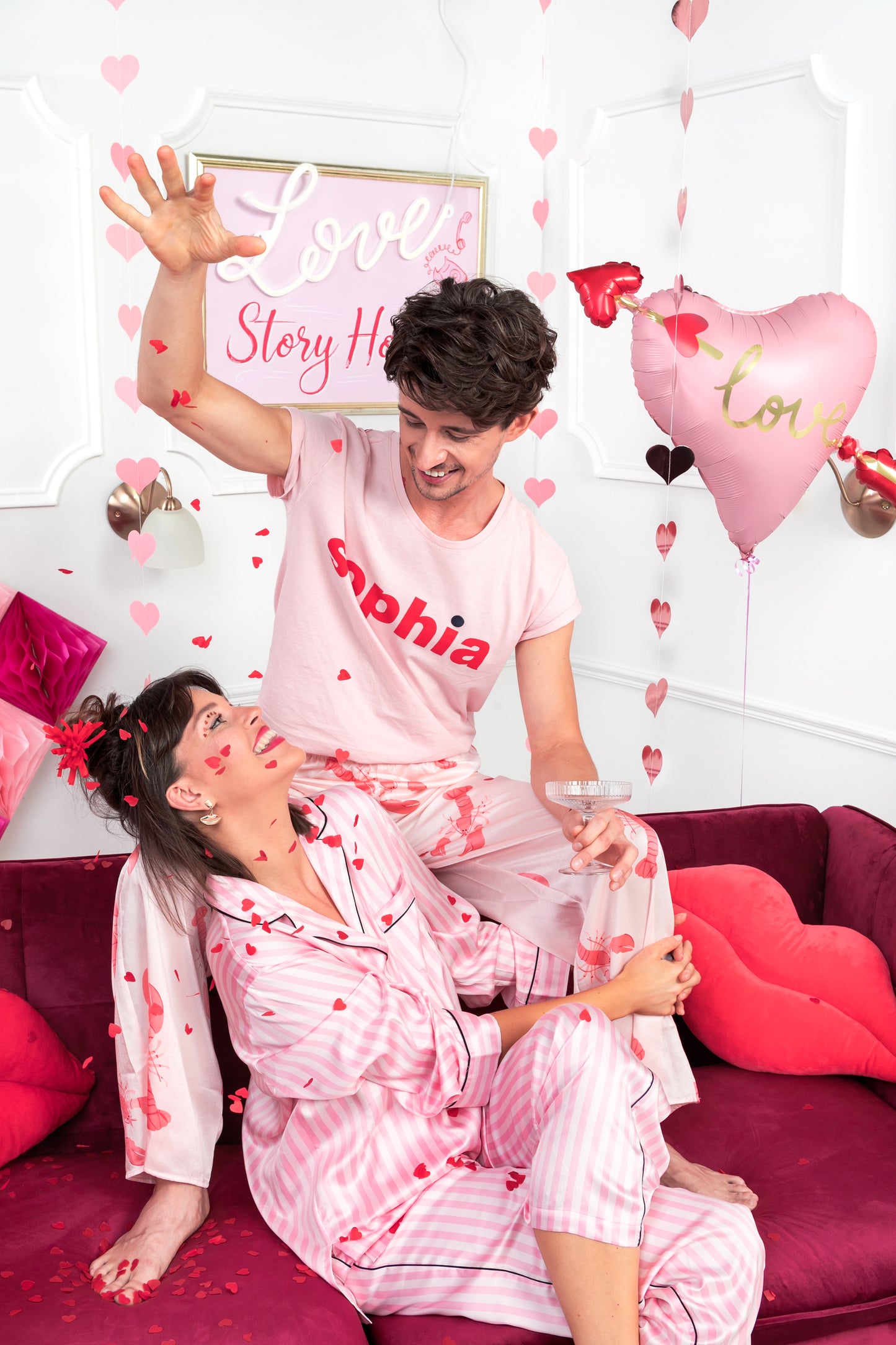 Couple celebrating while red heart confetti falls around them, romantic party decor sold in Toronto with shipping across Canada.