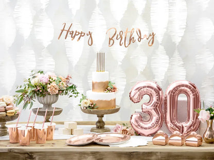 30th birthday table set up with rose gold happy birthday banner