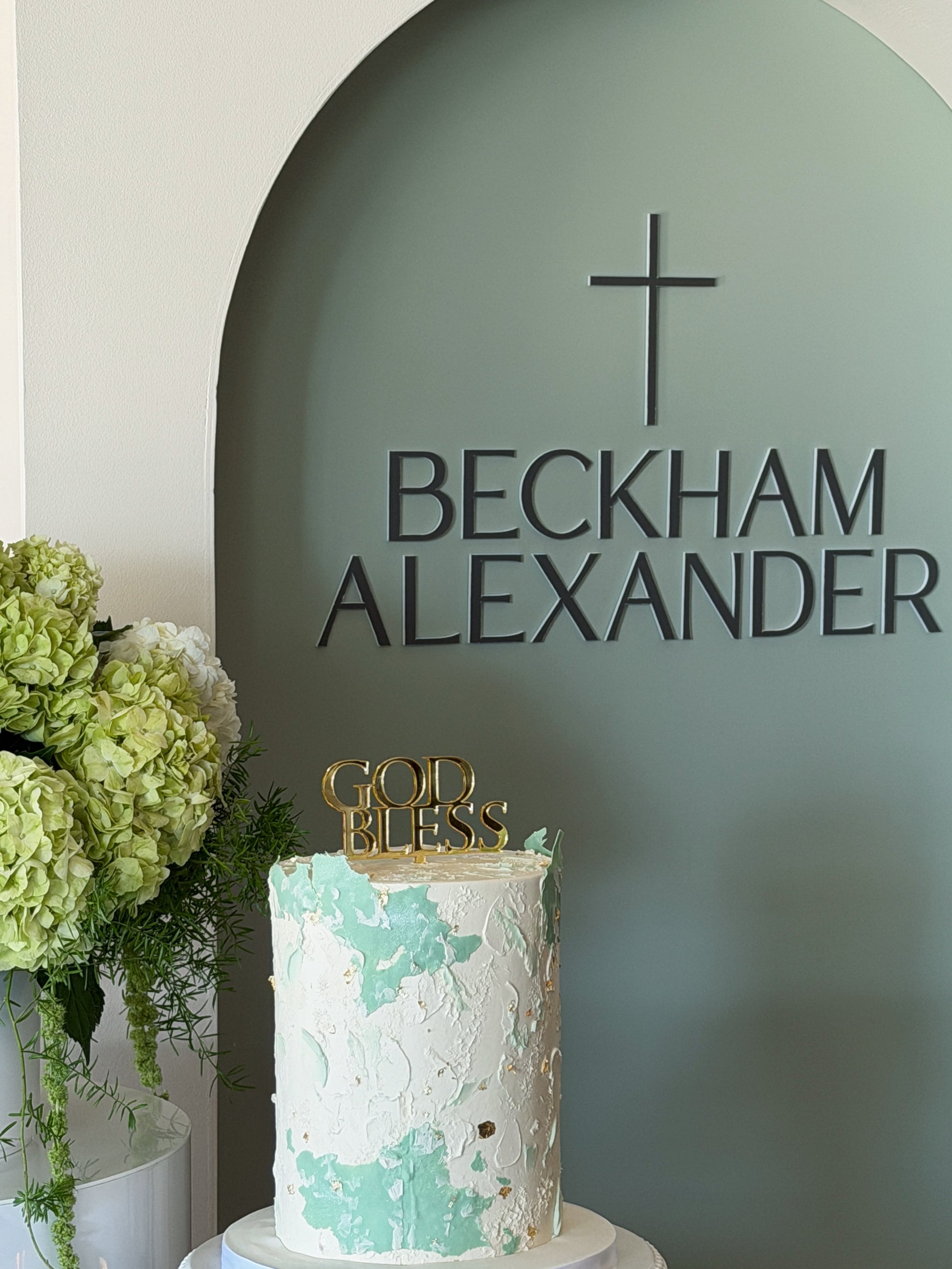 Sacrament event backdrop with sage oval panel and two white plinths with florals available in Toronto and shipping across Canada