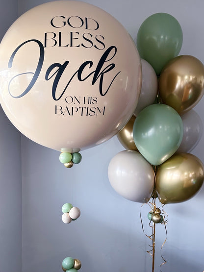 Balloon with 'God Bless Jack on his Baptism' text among other balloons against a light background