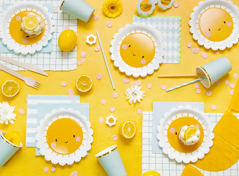 daisy themed party table with napkins, cups and plates